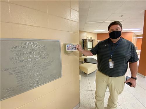 Liberty Middle Principal Shannon Brown installing placard in lobby